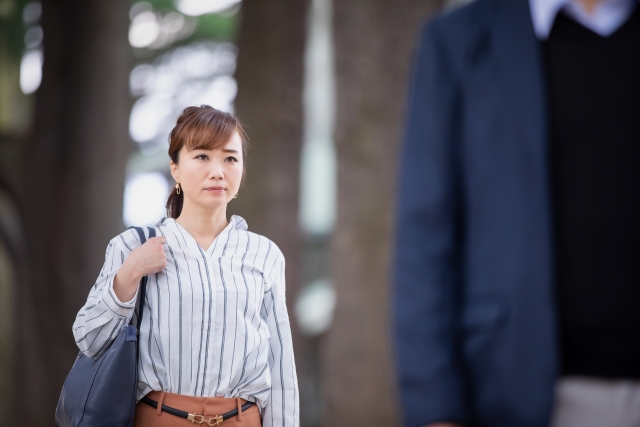 男性の後ろ姿を見つめる女性